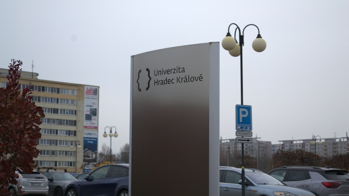 University sign with cars and buildings