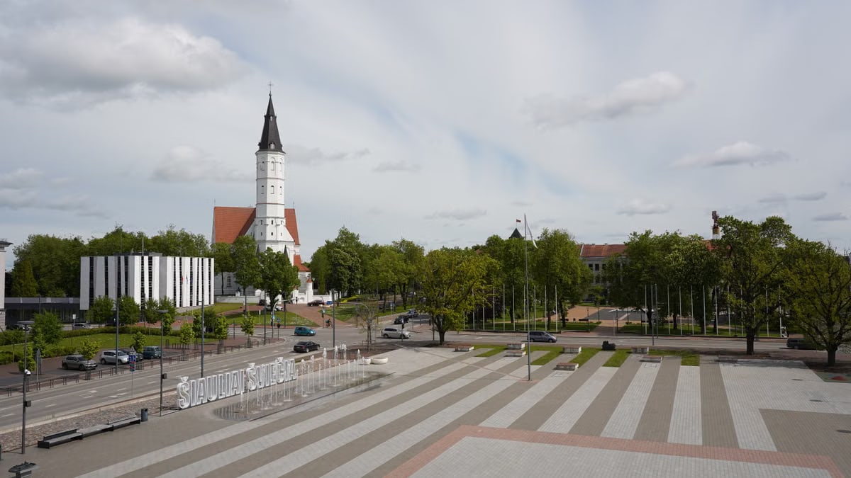 A view of Šiauliai, Lithuania featuring a prominent church and city square.